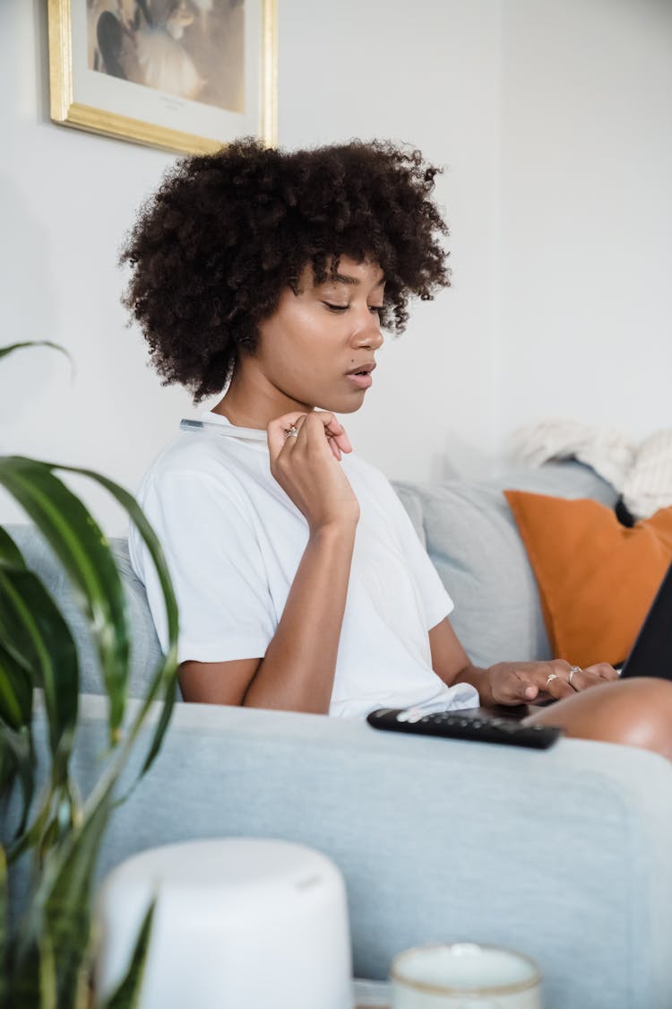 Woman Sitting On Sofa At Home Thinking