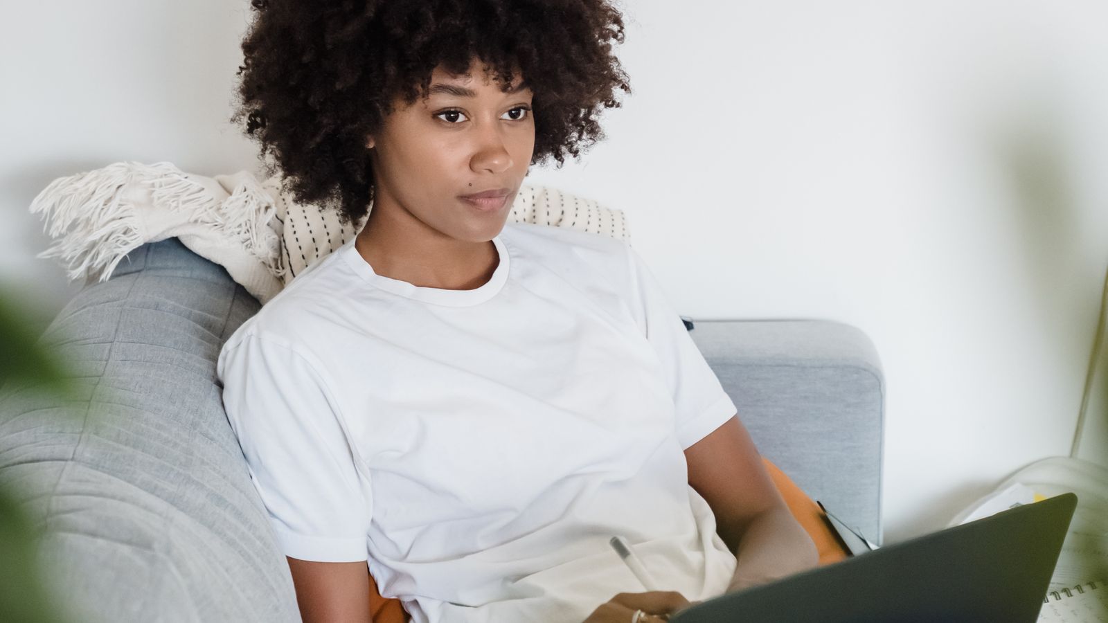 Mom typing on a laptop in a softly lit living room after kids are asleep