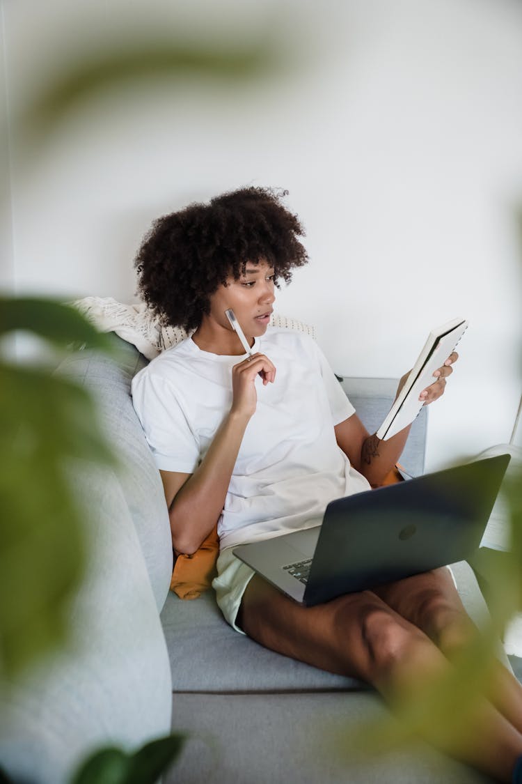 Woman Sitting On Couch Studying With Laptop