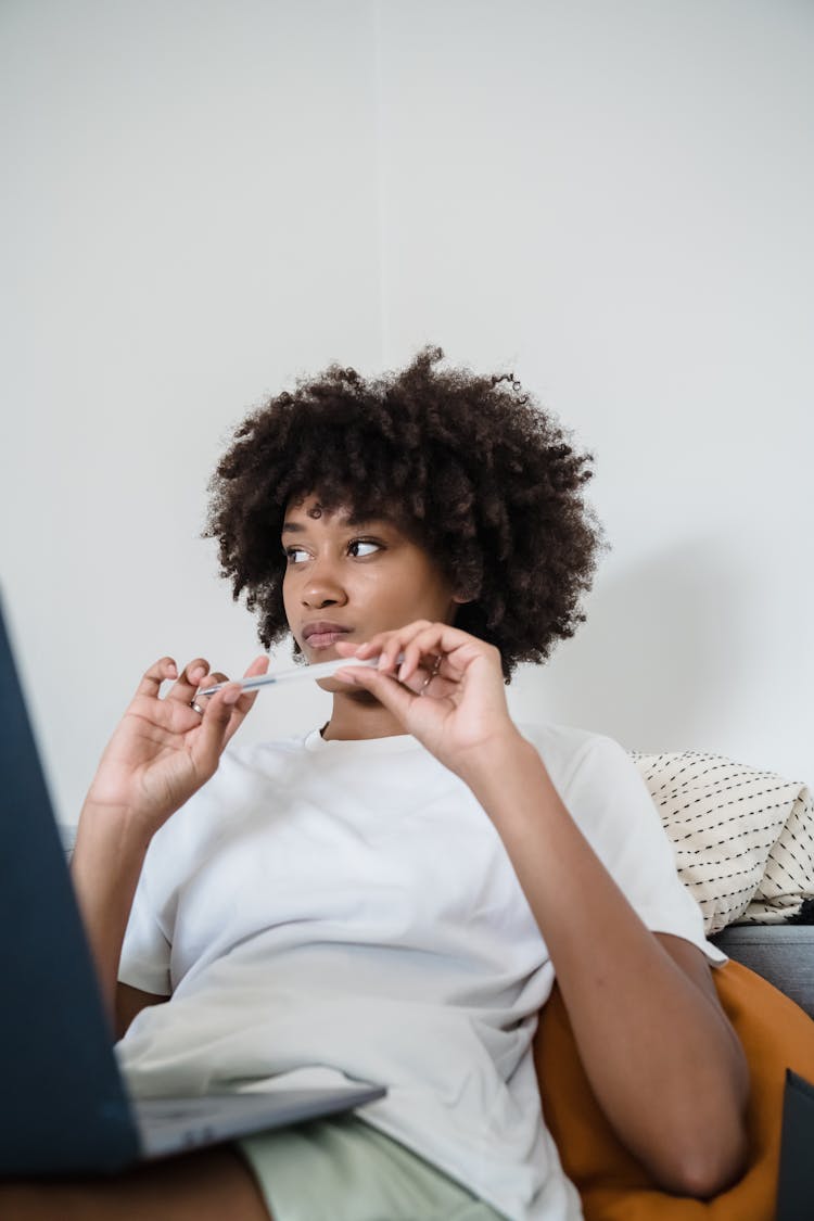 Woman Working On Laptop At Home Thinking