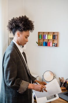 Businesswoman analyzing paperwork in a stylish home office workspace.