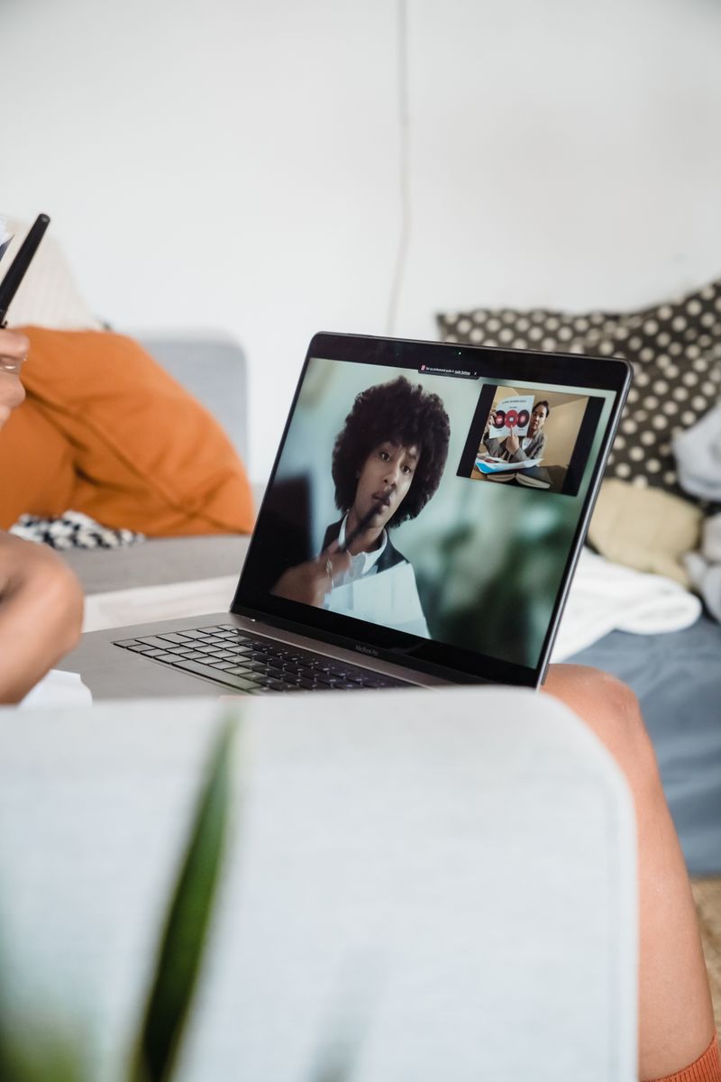 A person joining a video meeting from a laptop at home, the everyday surface where the flaw could strike.
