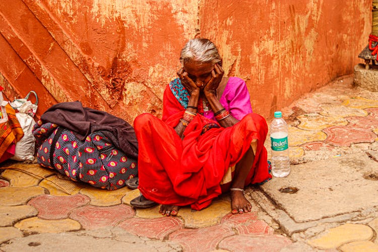 An Elderly Woman Resting While Sitting On The Ground