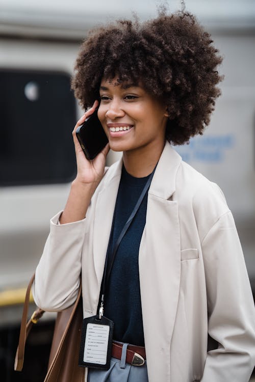 Woman at a Trainstation Talking on the Phone and Smiling