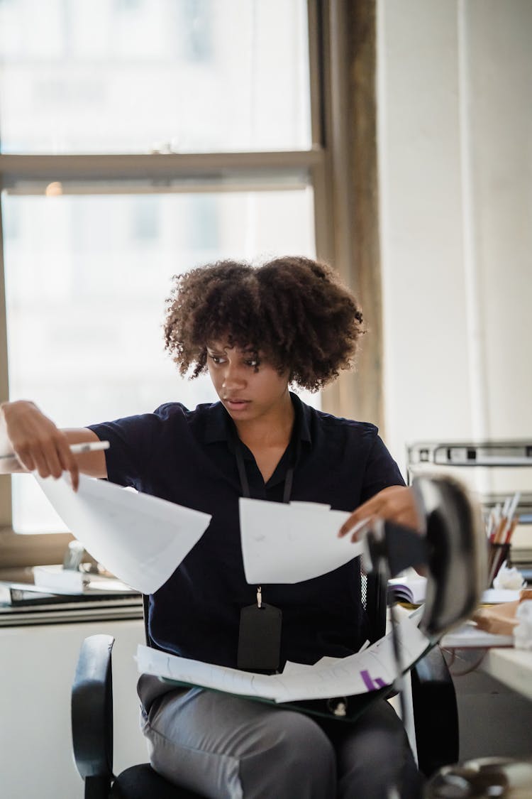 Woman Comparing Documents In An Office