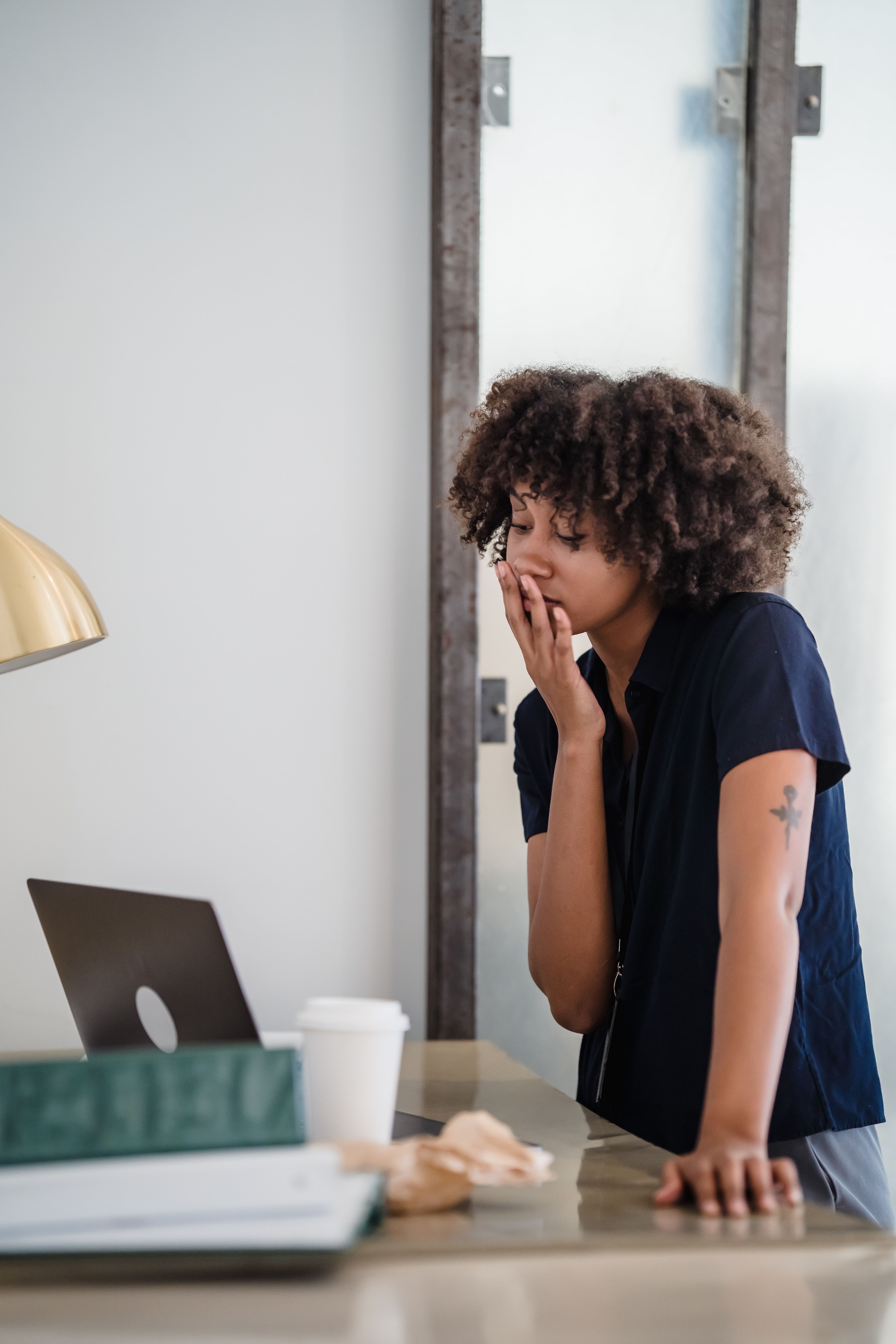 person yawning tired at office desk in daytime