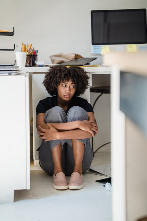 Free Woman Hiding under her Desk Stock Photo