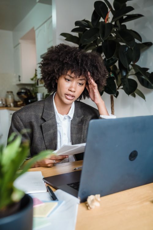 Free African American woman working remotely from home, focused on laptop. Stock Photo