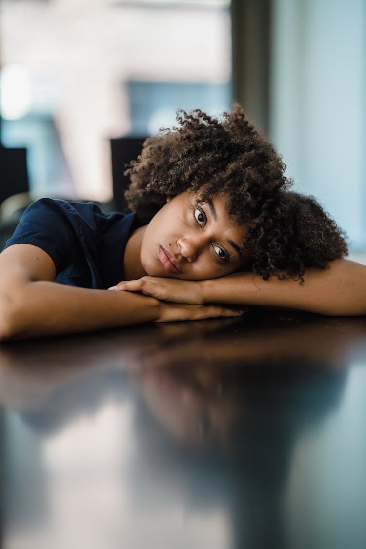 Portrait Of Woman Resting Head On Desk