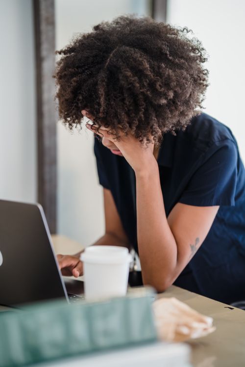 Free Woman in office focused on laptop work, showcasing remote work trend. Stock Photo