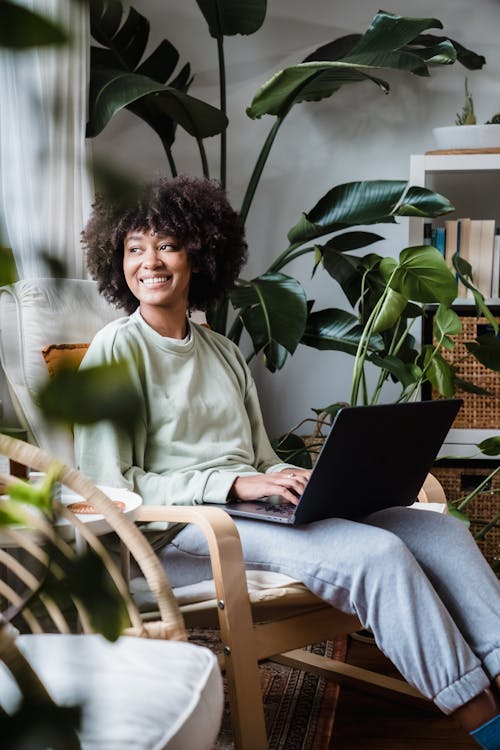 Woman Sitting with Laptop on Armchair