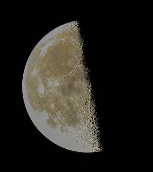 Free Close-up image of the third quarter moon with visible craters and texture against a dark sky. Stock Photo