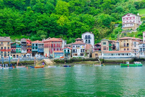 Free Charming coastal town view with colorful buildings and docked boats in Spain. Stock Photo