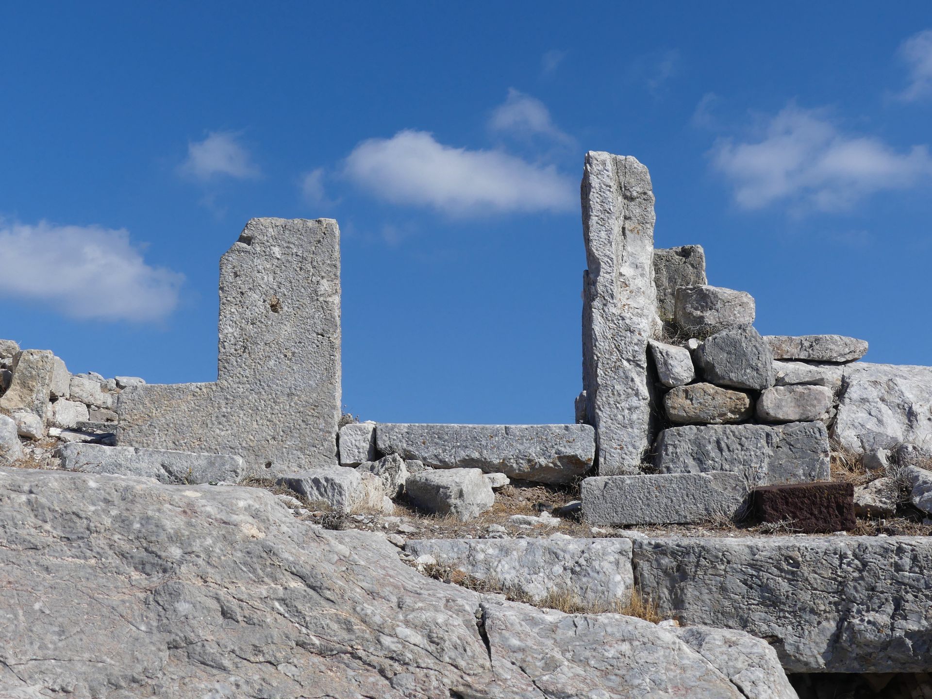 Explore the ancient stone ruins under a clear blue sky, capturing Greece's rich history.