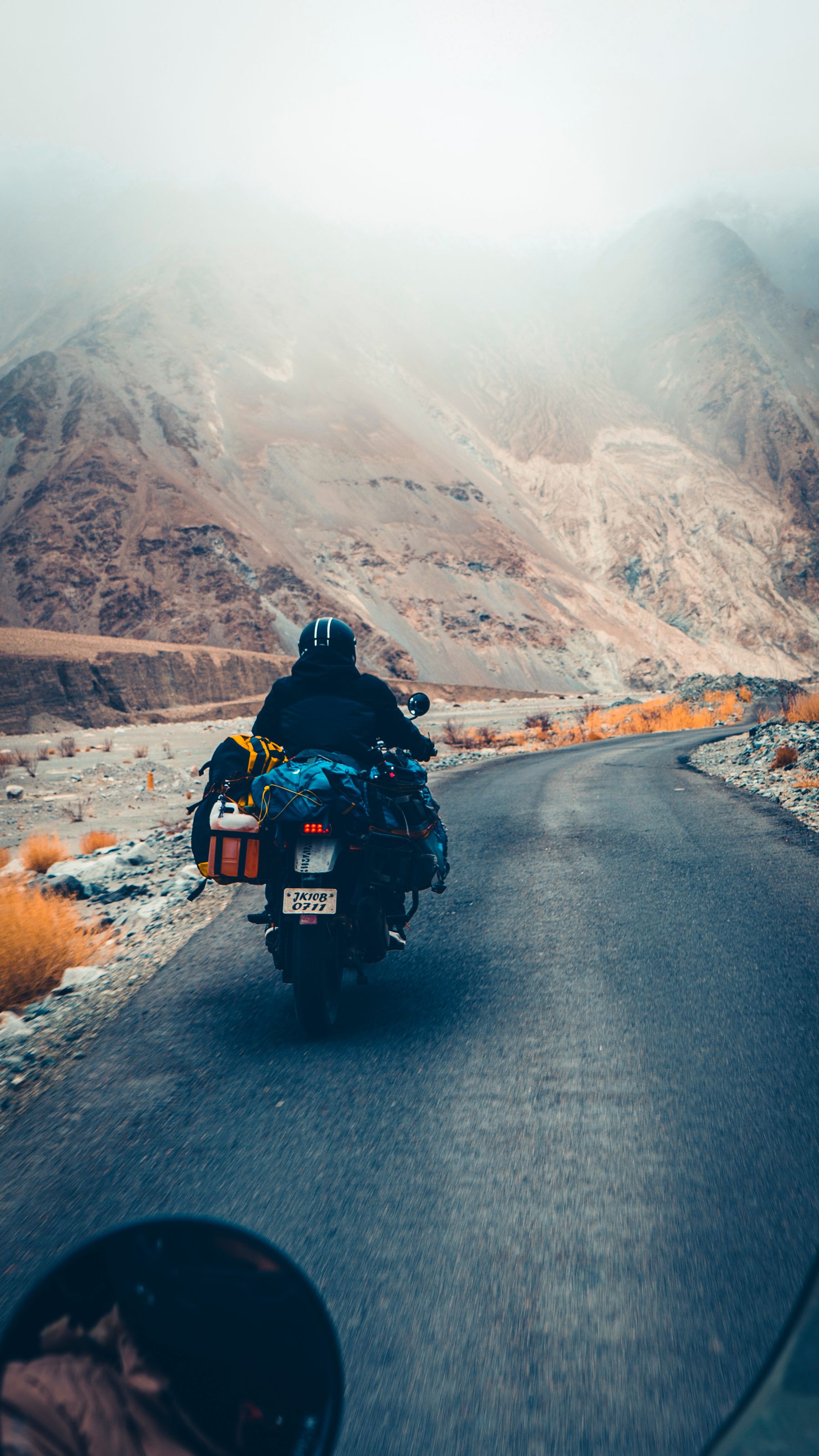 Motorcycle rider touring with luggage on a mountain road