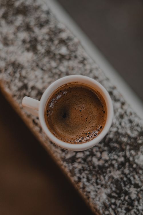 Free Top view of a steaming coffee cup on a textured surface, inviting and cozy. Stock Photo