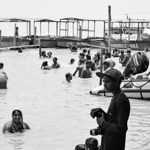 A Grayscale of People Swimming in the Sea