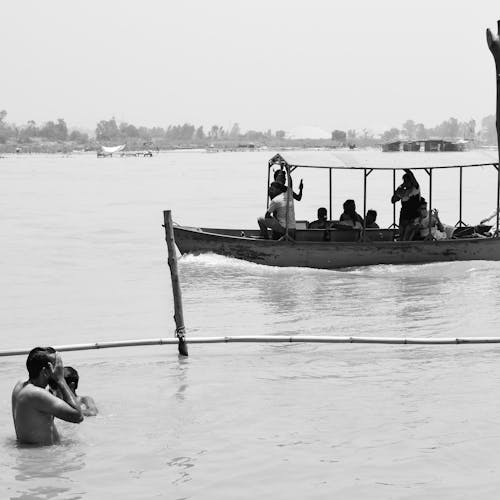 Grayscale Photography of People Riding on Boat