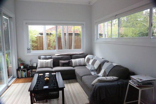 Modern indoor living room with grey sofa, coffee table, and bookshelves.