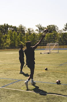Two athletes practice football throws on an outdoor field in Gatineau.