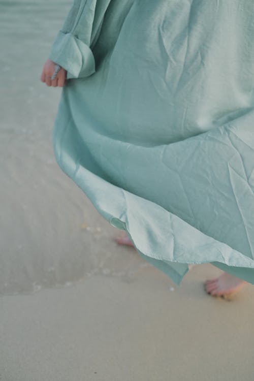 Person in Green Dress Standing on Beach