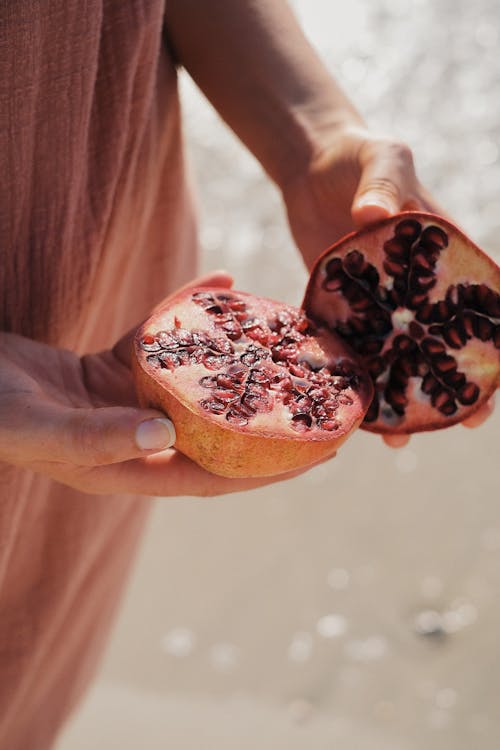 Hands Holding Open Pomegranate