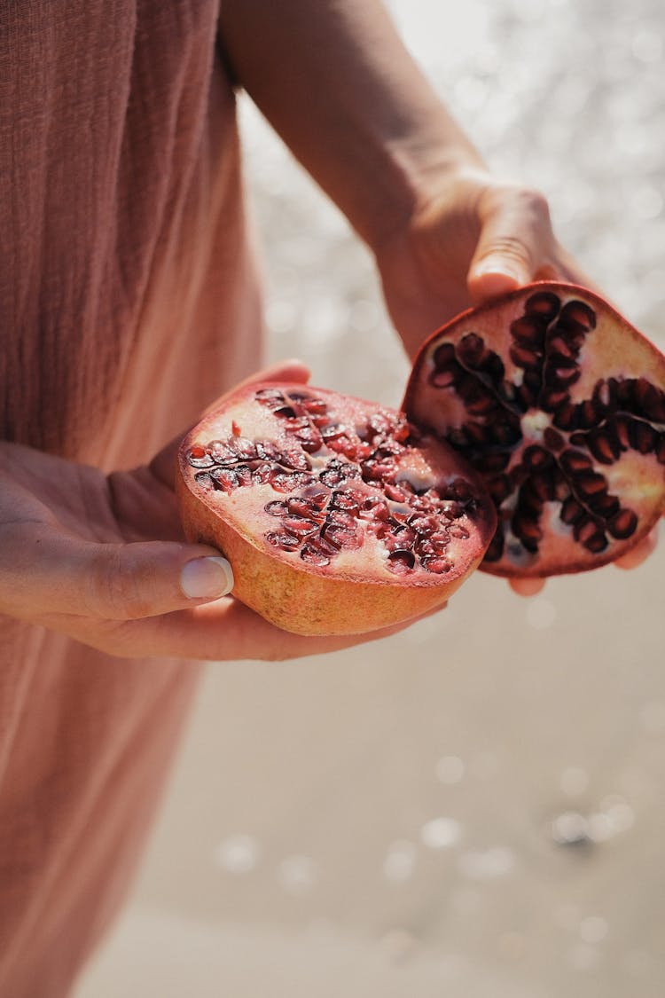 Hands Holding Open Pomegranate