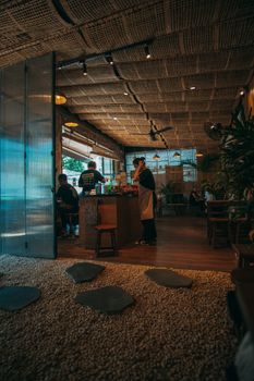 Warm café atmosphere with people enjoying drinks and staff serving customers.