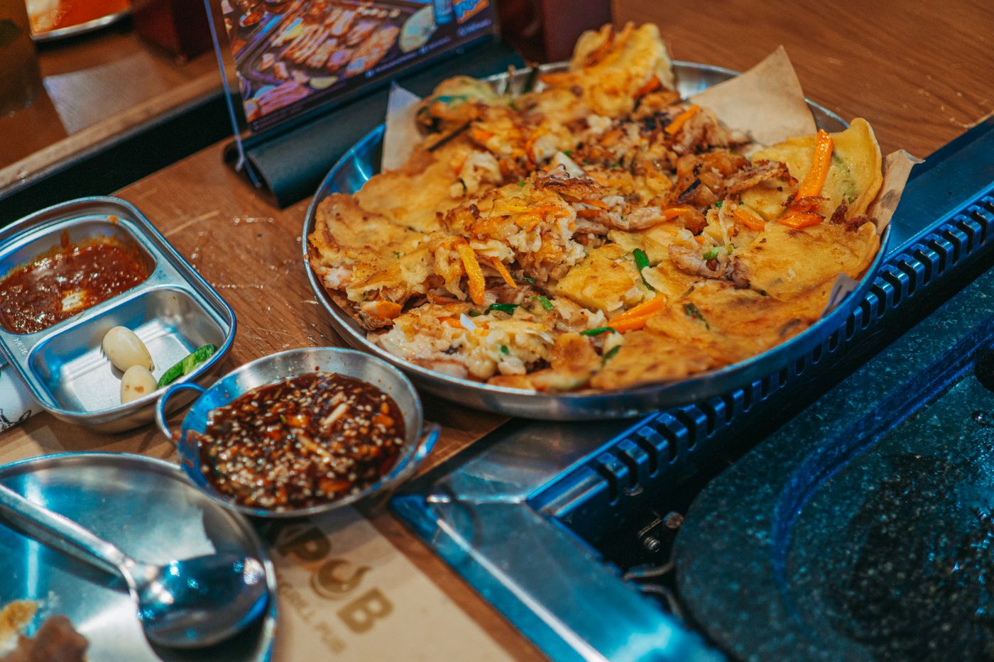Delicious Korean pajeon served with flavorful dipping sauces, perfect for food photography.
