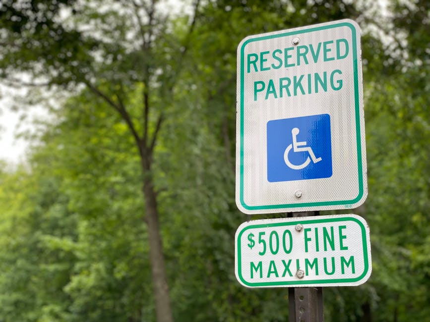 Close-up of a reserved parking sign with a fine notice, surrounded by lush greenery.