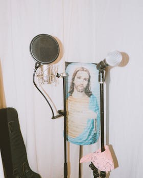 A unique studio setup featuring microphones and a religious icon tapestry creating an intriguing juxtaposition.