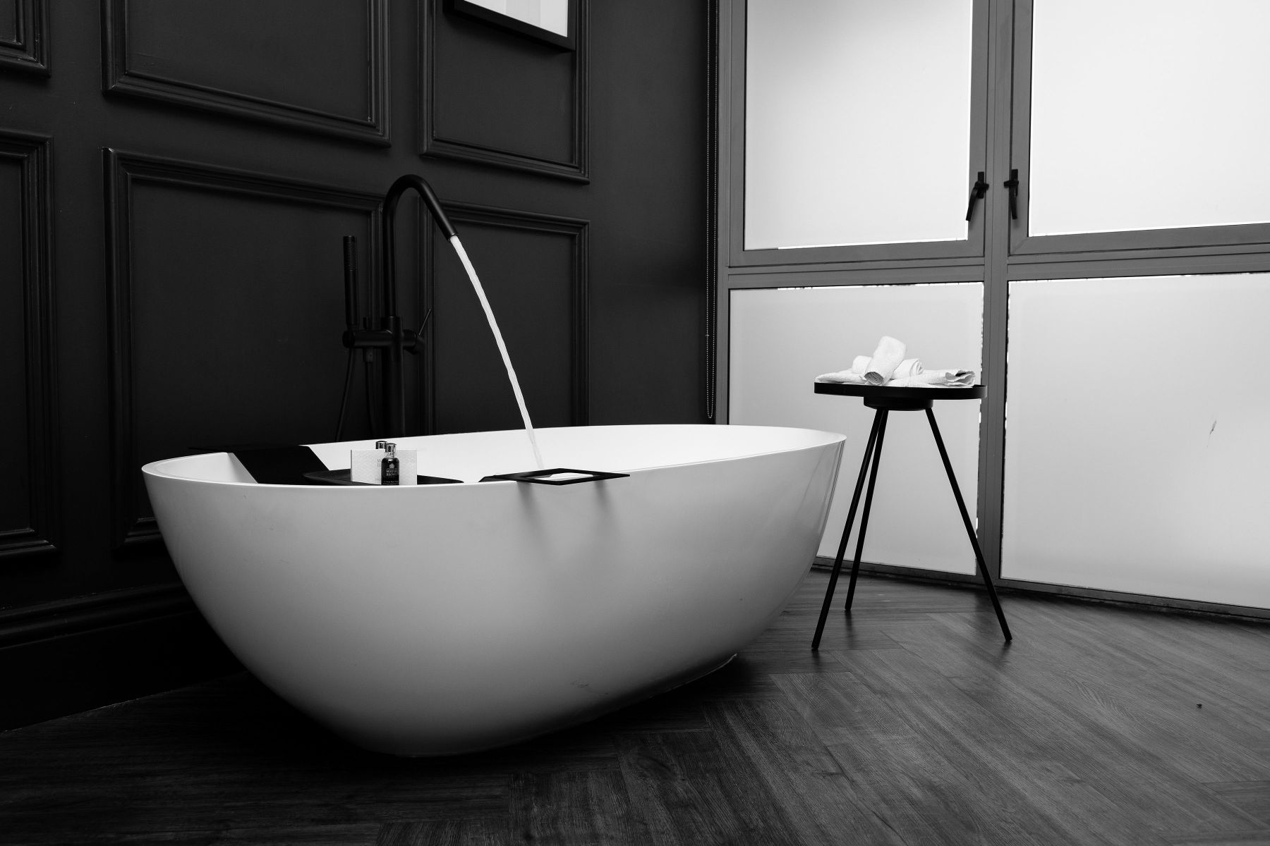 White freestanding bathtub in an elegant black and white bathroom