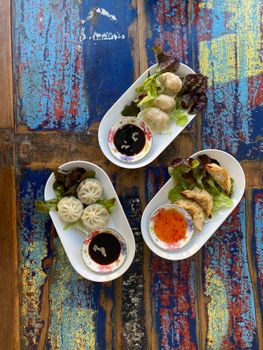 Enjoy a delectable assortment of homemade dumplings with sauces, styled on a vibrant table. Perfect for food lovers.