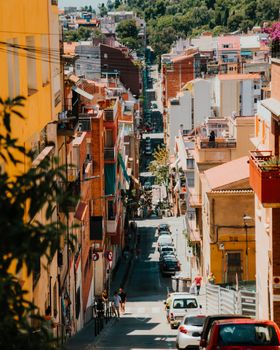 A vibrant summer street view in Barcelona showcasing colorful buildings and bustling activity.