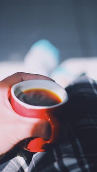 Cozy scene of a hand holding a cup of coffee in São Paulo, Brazil.