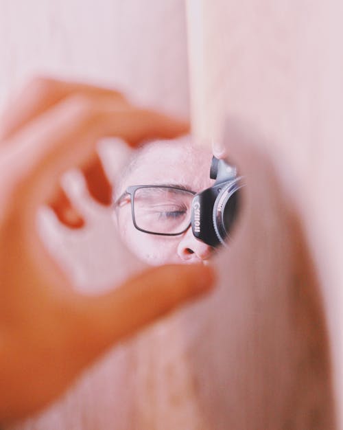 A Photographer Taking Photo Through a Mirror