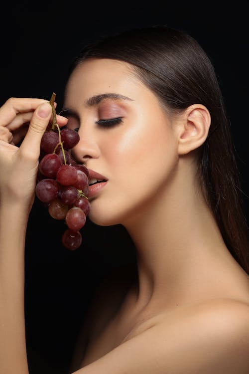 Základová fotografie zdarma na téma brunetka, černé pozadí, hrozny