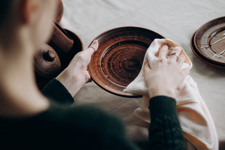 Woman Cleaning Clay Plates