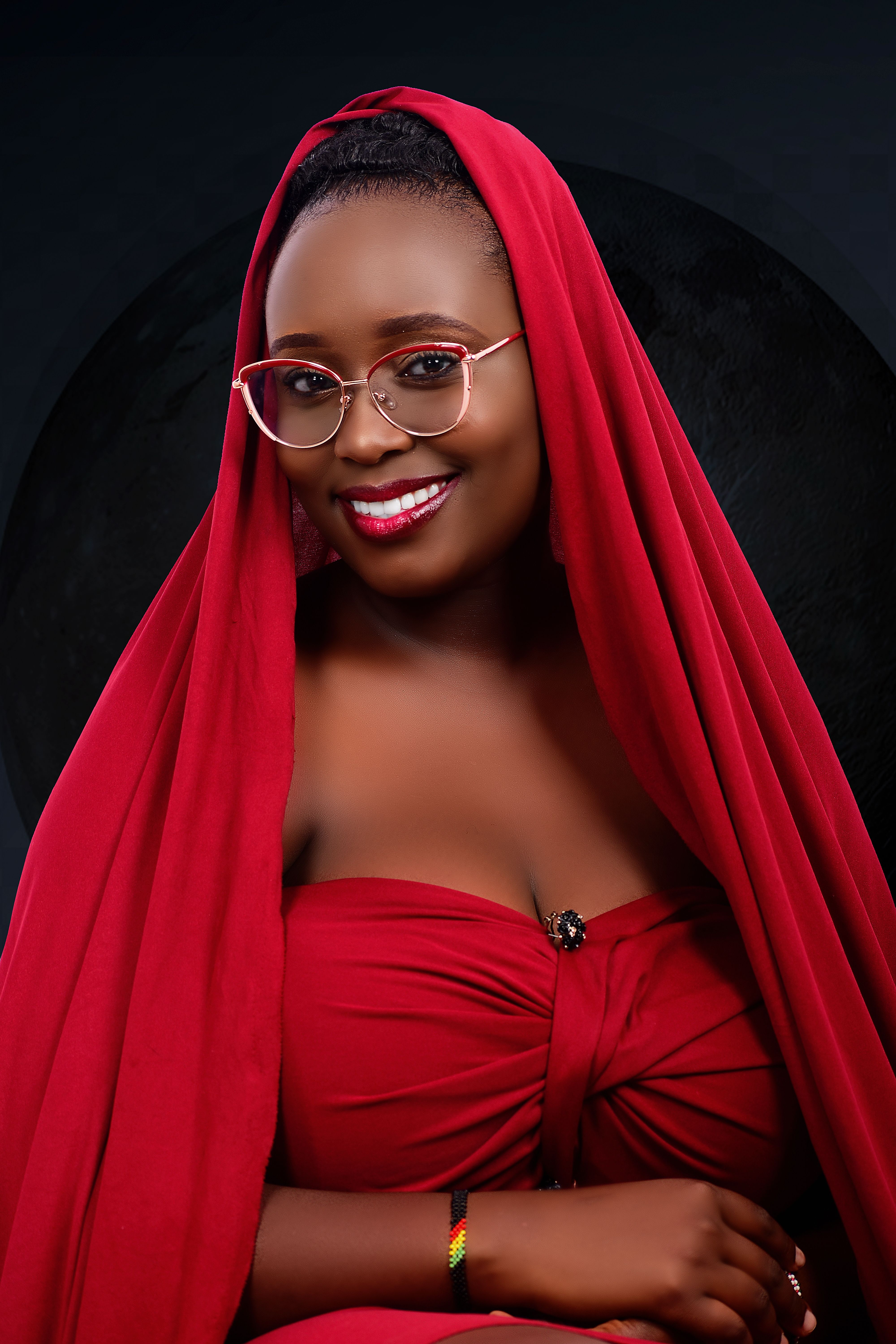 Charming portrait of a woman in a red outfit and glasses, smiling confidently.