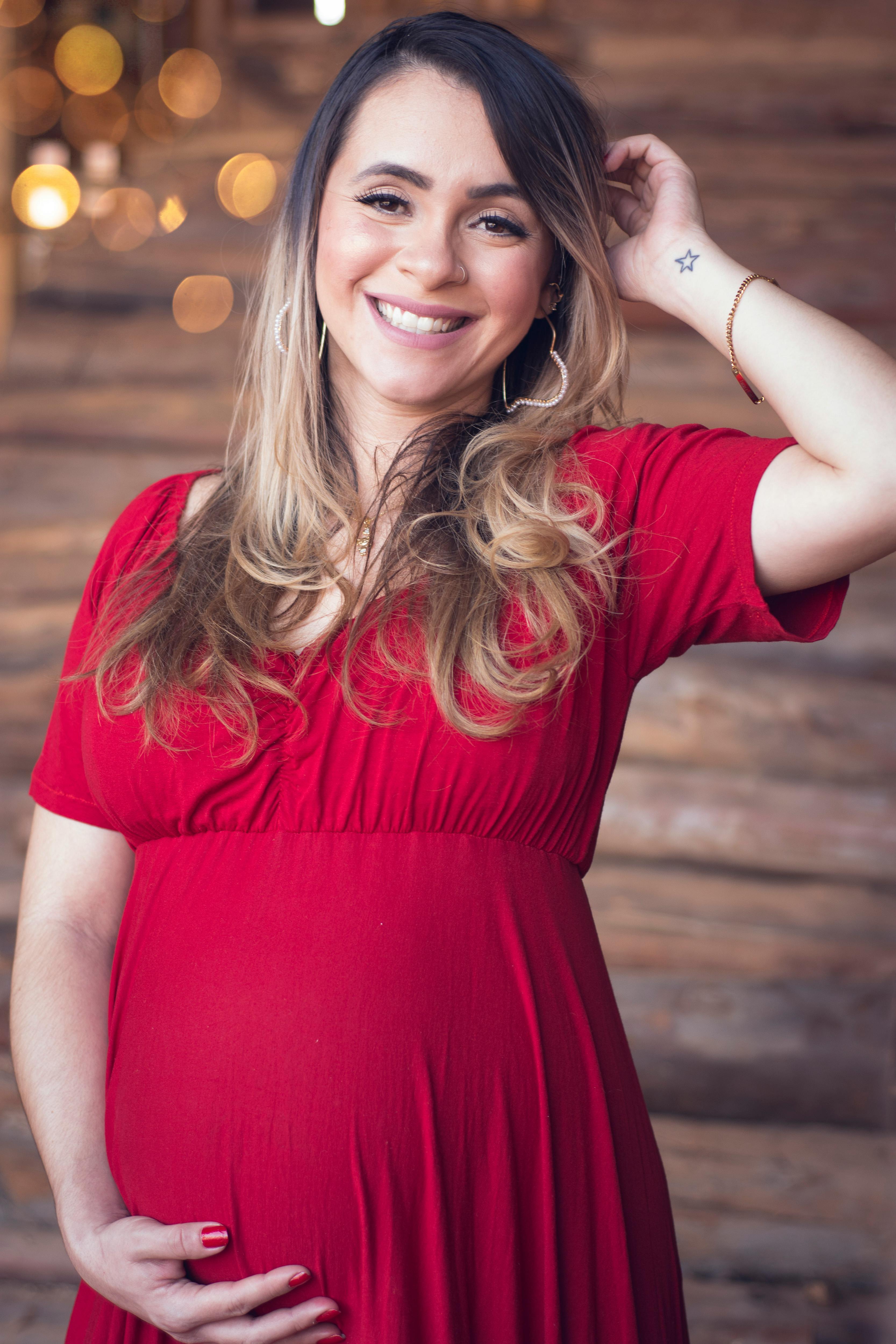 close up shot of a pregnant woman wearing red dress