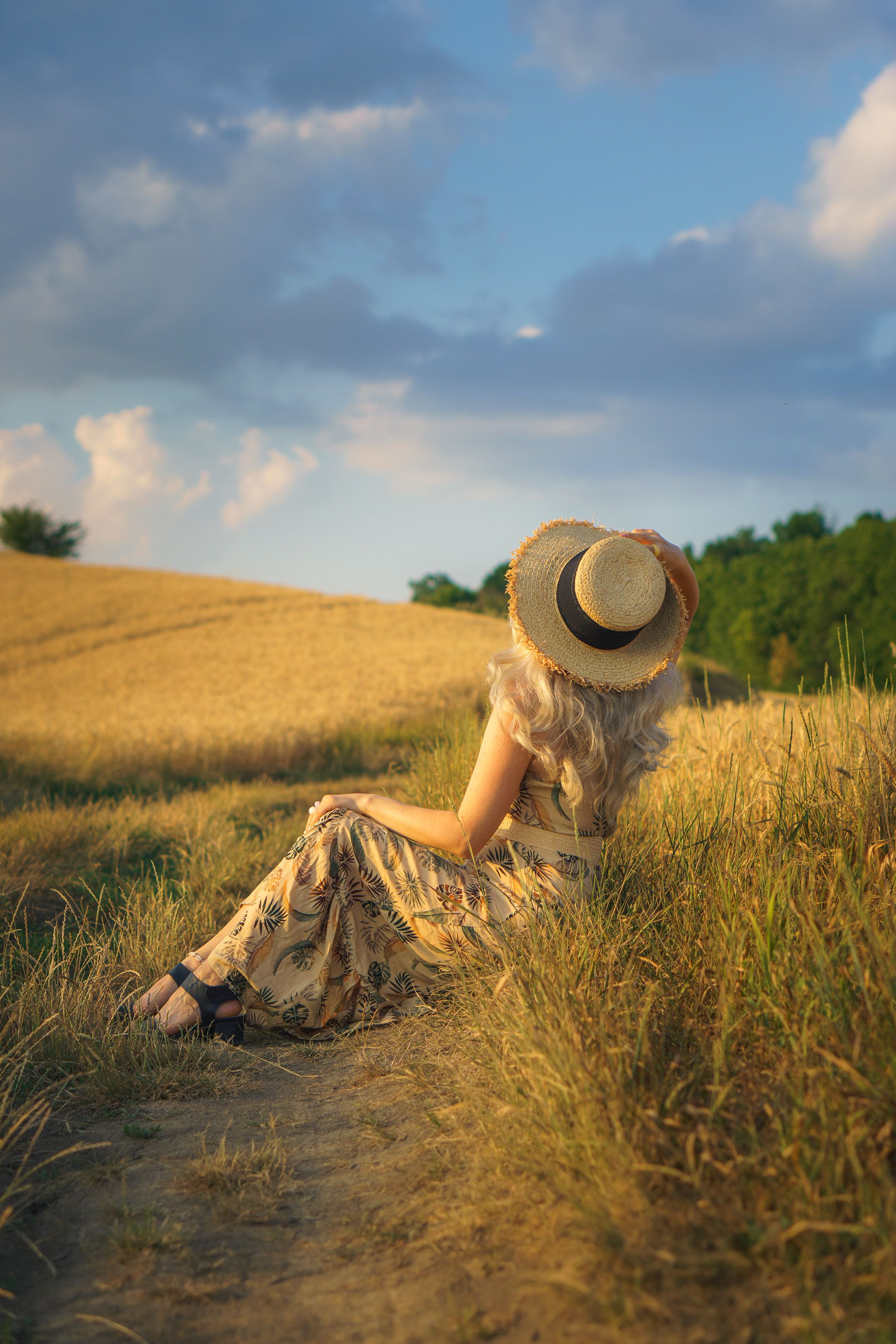 Woman in Summer Hat Sitting in Field · Free Stock Photo