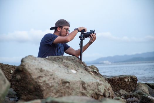 Photographer focused on capturing a serene seascape during the day.