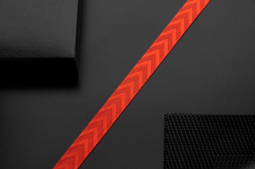 Close-Up Shot of a Red Strap on a Black Surface