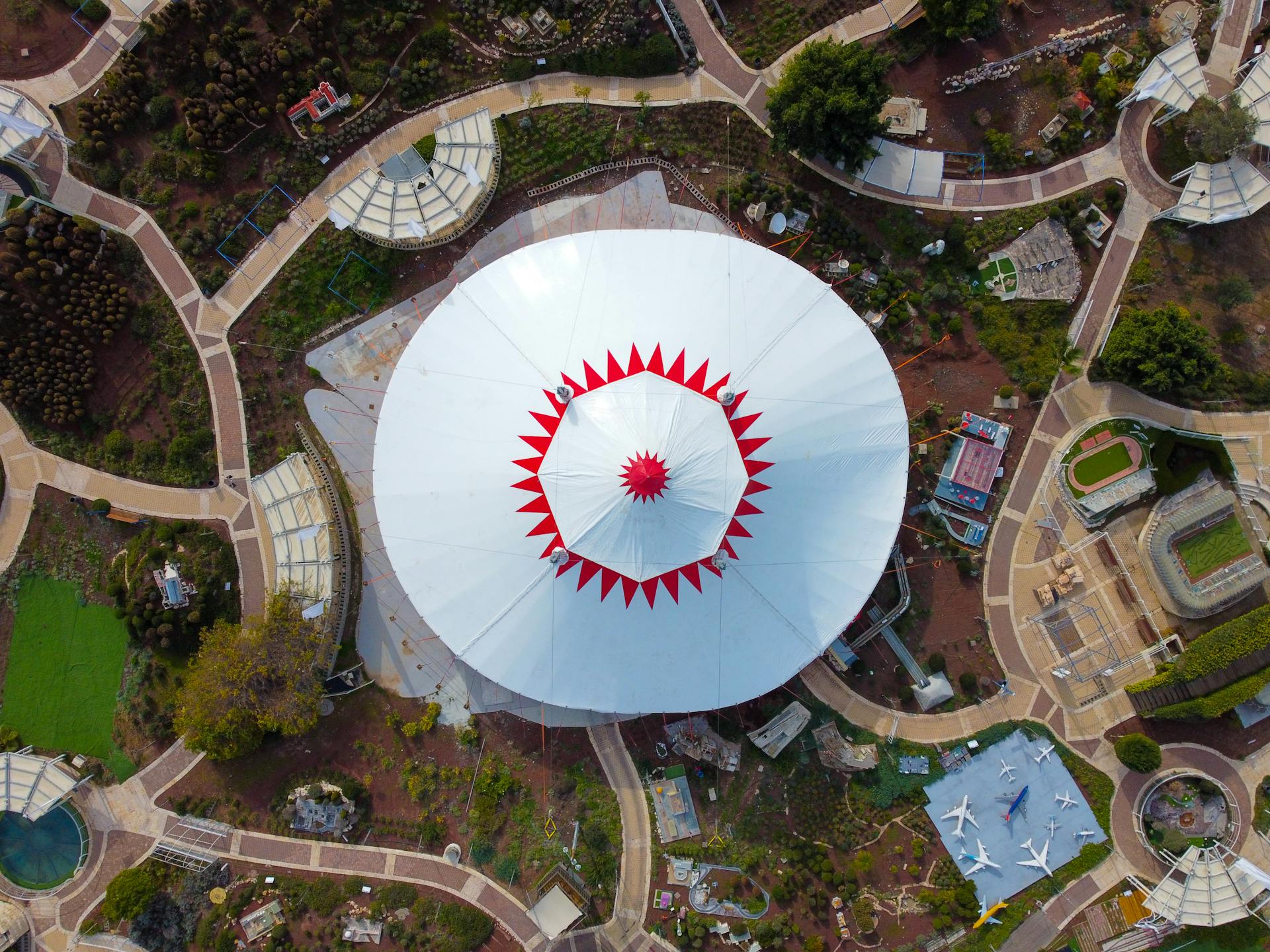 Drone shot of a red and white circular structure in Latrun, Israel showcasing unique architecture.