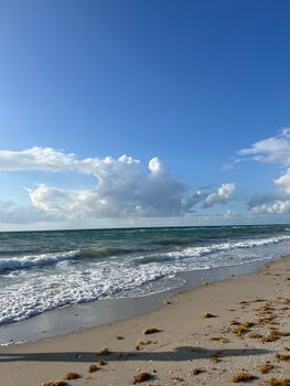 A tranquil beach scene with crashing waves and a vibrant blue sky, perfect for relaxation.