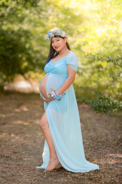 Woman in Blue Dress Having a Maternity Shoot