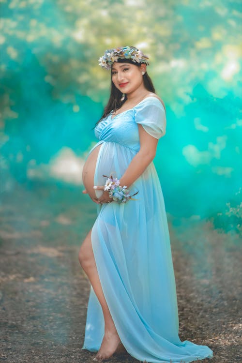 Kostenloses Stock Foto zu babybauch, barfuß, blaues kleid