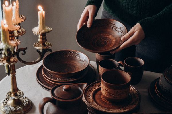 Warm-toned pottery and candlesticks in a table setting — Liudmyla Shalimova on Pexels