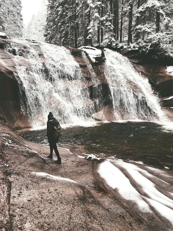 A Person Walking Near the Mumlava Falls