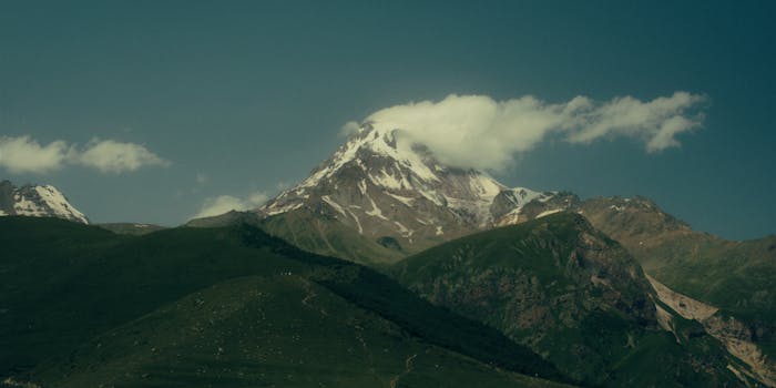 Breathtaking view of Mount Kazbek with snow peaks and clouds.